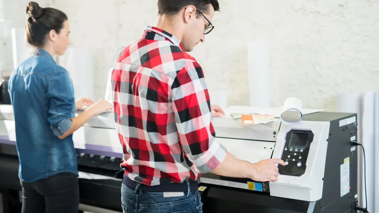 Équipe d'imprimerie pilotant la production sur une machine grand format
