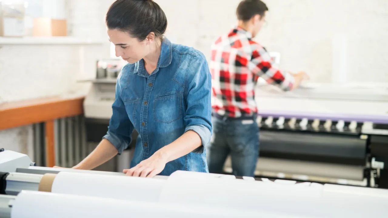 Sérigraphe préparant un tirage sur son poste de travail dans un atelier de marquage