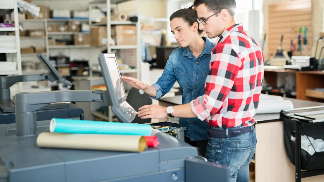 Atelier de production d'une imprimerie avec presses en fonctionnement et opérateurs au travail