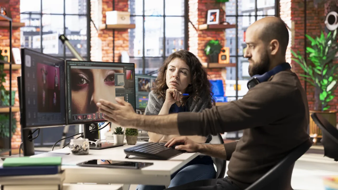 Équipe de prépresse travaillant sur des visuels devant plusieurs écrans
