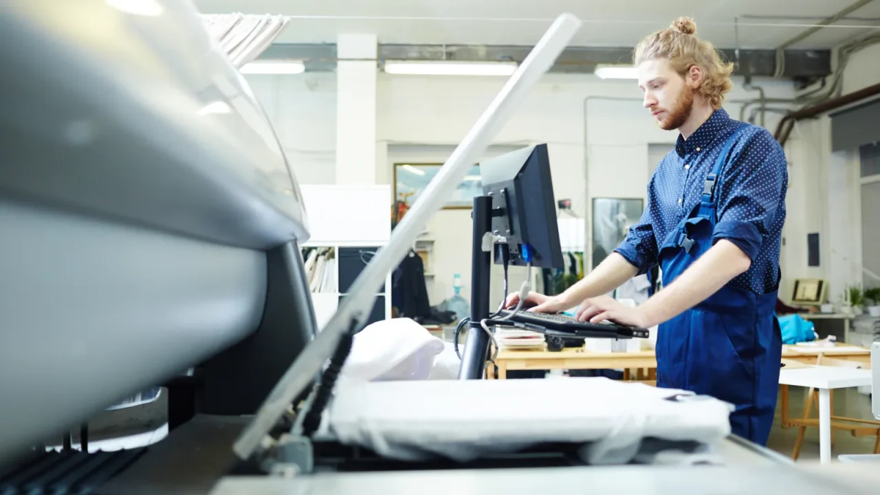 Imprimeur au travail devant sa machine dans un environnement de production industriel