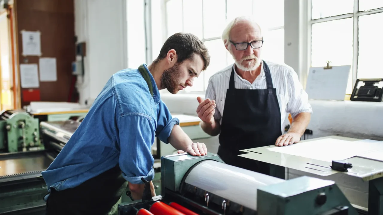 Formateur accompagnant un nouvel utilisateur sur le logiciel de gestion d'une imprimerie