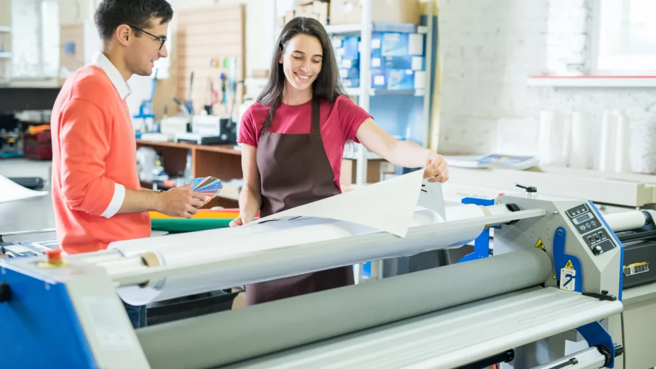 Opérateurs suivant les étapes de production sur une imprimante professionnelle en atelier